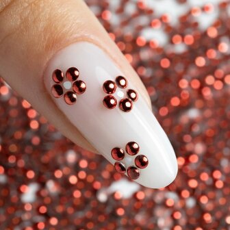ronde rode metallic studs als bloemen op nagel