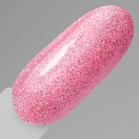 Showcase van de lichtroze kleur en glitters op de nagel.