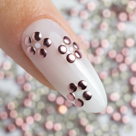 rosegouden nail art studs als 3d bloemenpatroon op nagel